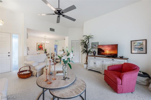 living room with ceiling fan with notable chandelier and light colored carpet