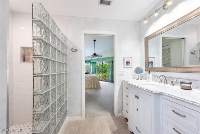 bathroom with a shower, vanity, and ceiling fan