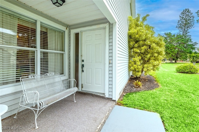 entrance to property with a lawn