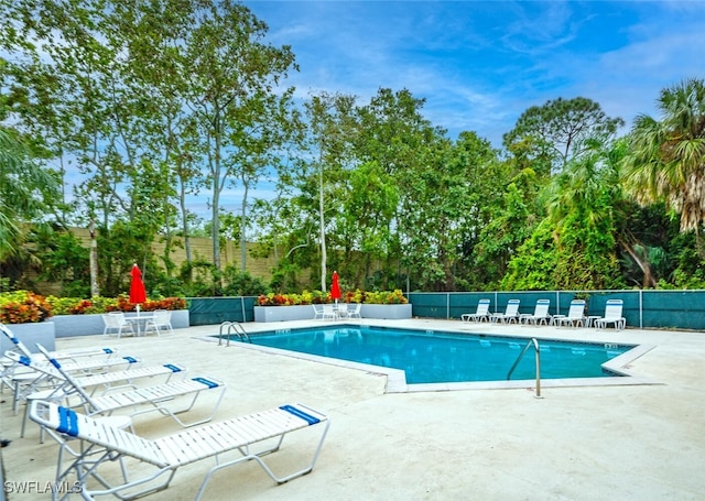 1311 Monarch Cir, Naples, FL 34116 - community pool with a patio and view of wooded area