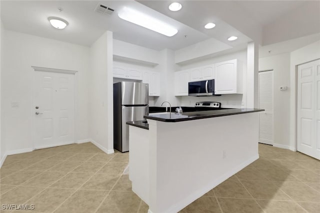 kitchen with kitchen peninsula, white cabinetry, light tile patterned floors, and stainless steel appliances