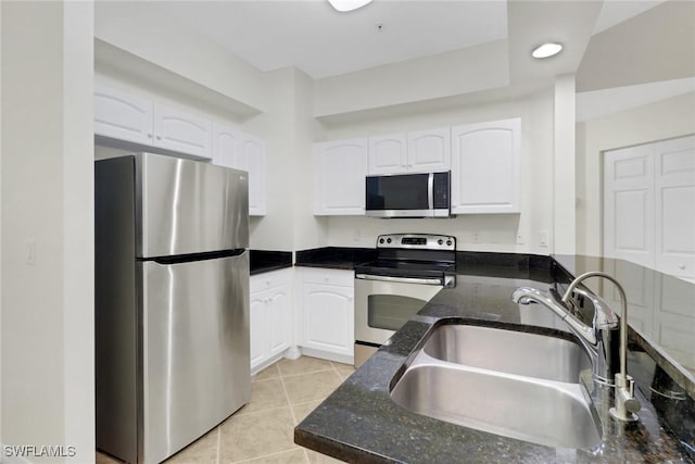 kitchen with light tile patterned floors, white cabinets, appliances with stainless steel finishes, and sink