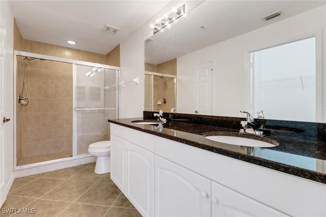 bathroom featuring toilet, walk in shower, vanity, and tile patterned flooring