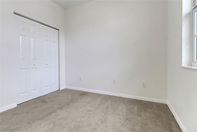 unfurnished bedroom with a closet and carpet flooring