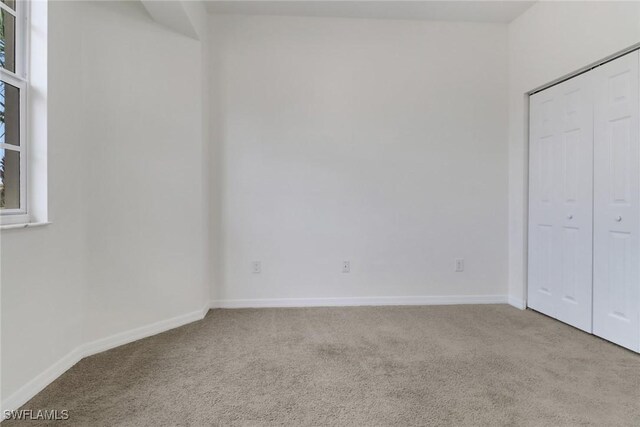 unfurnished bedroom featuring light carpet