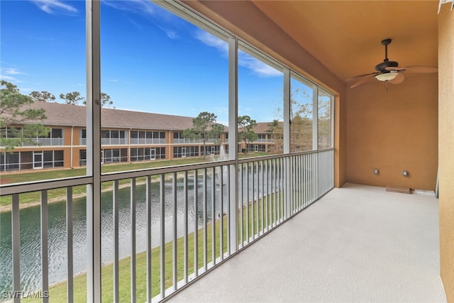 unfurnished sunroom featuring a water view and ceiling fan