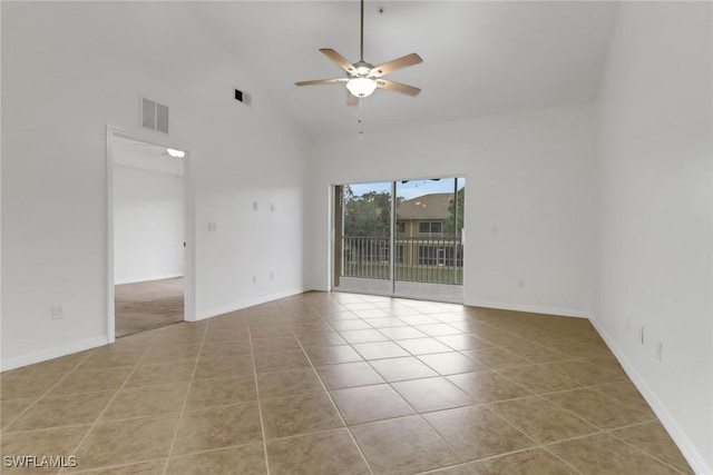 empty room featuring ceiling fan, light tile patterned floors, and a high ceiling