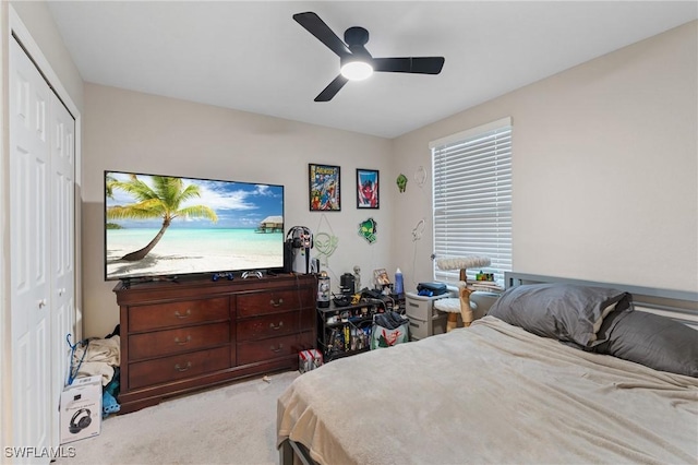 carpeted bedroom featuring ceiling fan and a closet