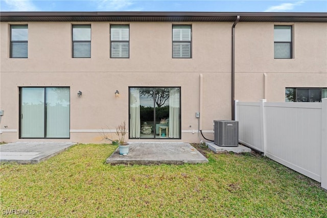 rear view of property featuring a yard, a patio, and central air condition unit