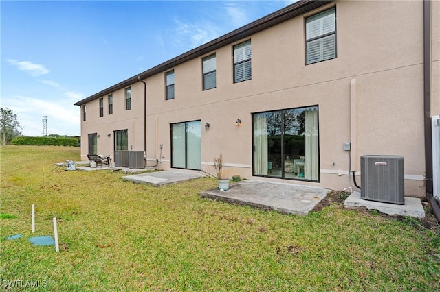 back of property with a patio area, central AC, and a lawn