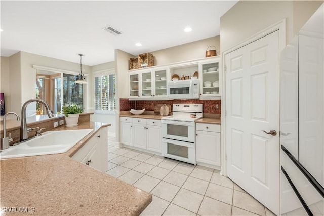 kitchen featuring tasteful backsplash, visible vents, light tile patterned flooring, white appliances, and a sink