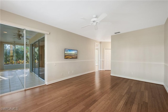 unfurnished room featuring visible vents, baseboards, a ceiling fan, and wood finished floors