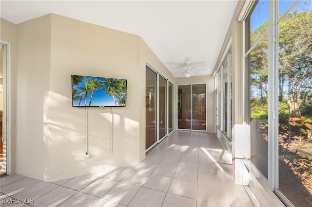 unfurnished sunroom with ceiling fan