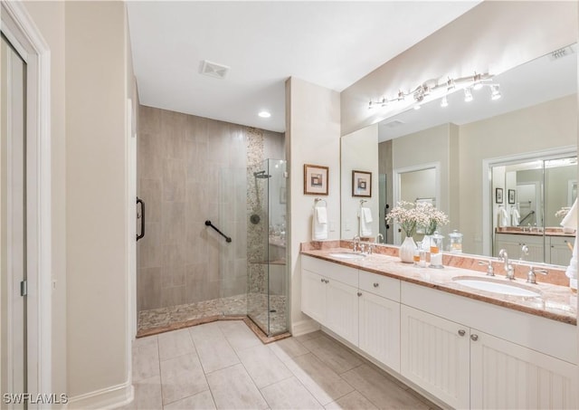 bathroom with a sink, visible vents, double vanity, and a shower stall