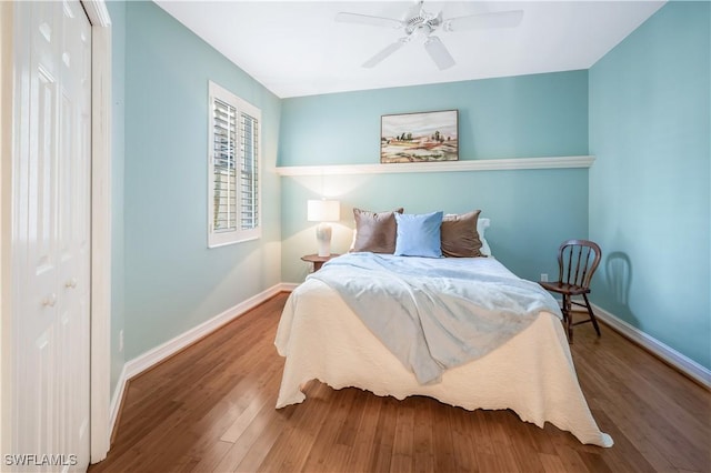 bedroom with a closet, a ceiling fan, baseboards, and wood finished floors