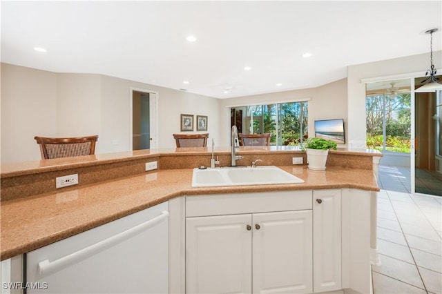 kitchen featuring light tile patterned floors, recessed lighting, white dishwasher, white cabinetry, and a sink