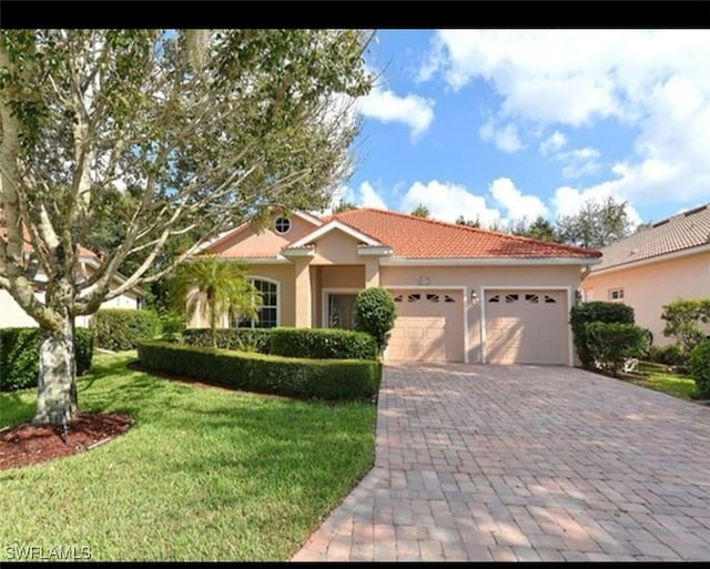 mediterranean / spanish house with a front yard and a garage