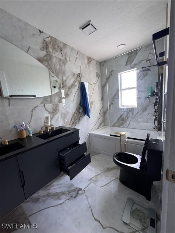 full bathroom with toilet, tiled shower / bath combo, tile walls, and vanity