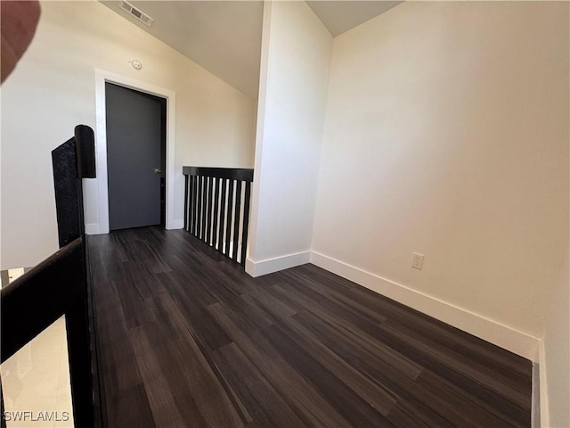 interior space featuring dark wood-type flooring and vaulted ceiling