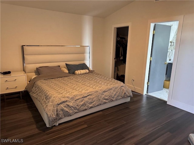 bedroom featuring a spacious closet, dark hardwood / wood-style floors, a closet, and lofted ceiling