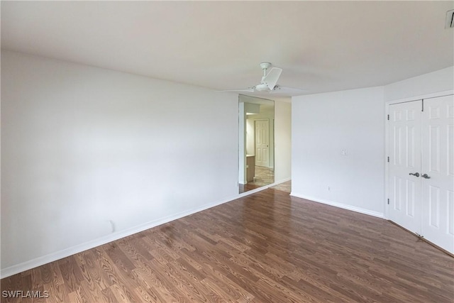 spare room featuring ceiling fan and dark wood-type flooring