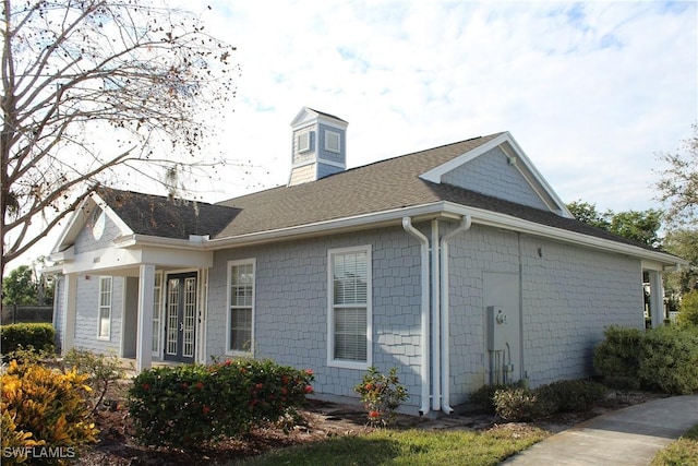 view of side of property featuring a shingled roof