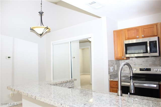 kitchen with stainless steel appliances, backsplash, and light stone countertops