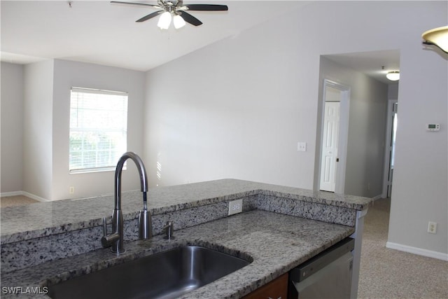 kitchen featuring light colored carpet, stainless steel dishwasher, a sink, light stone countertops, and baseboards