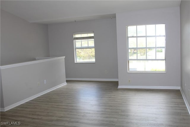 empty room with baseboards and wood finished floors