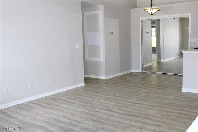 unfurnished room with baseboards and wood finished floors