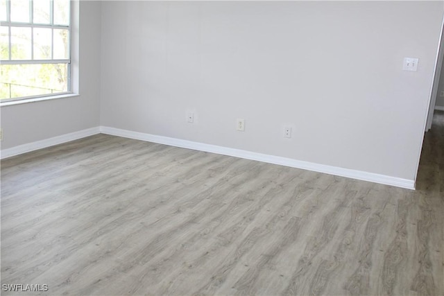 unfurnished room with baseboards and wood finished floors