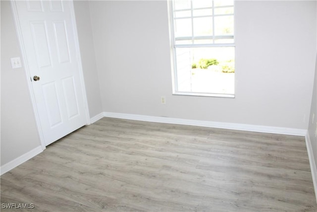 unfurnished room featuring baseboards and wood finished floors