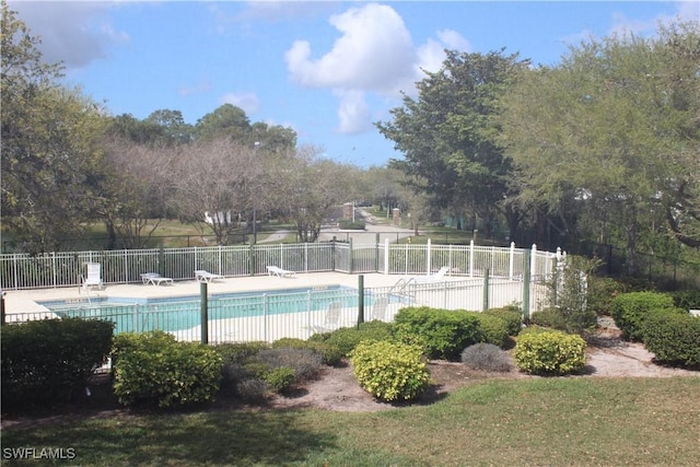 pool with a patio area and fence