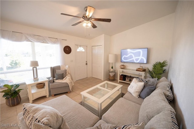 living room with ceiling fan, light tile patterned floors, and vaulted ceiling