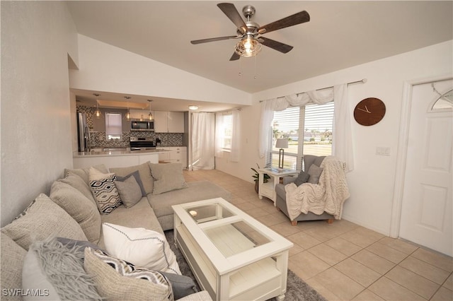 living room featuring ceiling fan, light tile patterned flooring, and vaulted ceiling