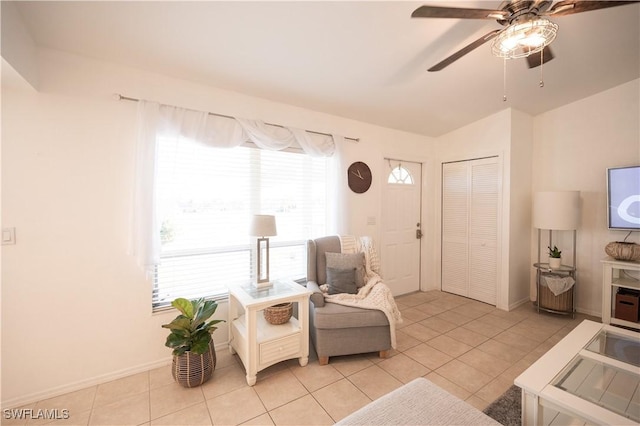 living area with ceiling fan, a wealth of natural light, and light tile patterned floors