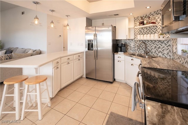 kitchen with kitchen peninsula, appliances with stainless steel finishes, white cabinetry, and sink