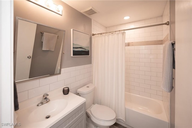 full bathroom with vanity, decorative backsplash, tile walls, toilet, and shower / bath combo