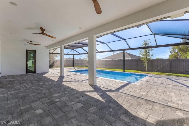 view of swimming pool featuring ceiling fan, a lanai, and a patio