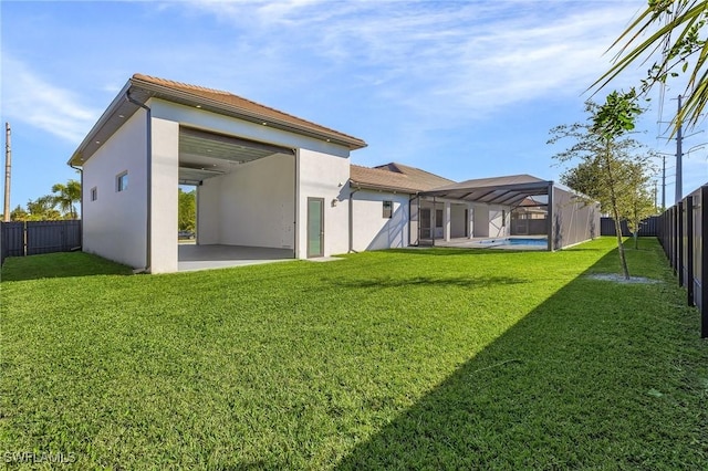 rear view of house with a fenced in pool, a yard, a patio, and glass enclosure