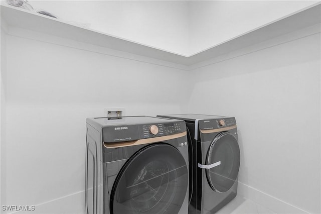 laundry area featuring washer and dryer and tile patterned flooring