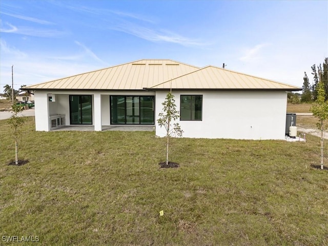 back of house with a yard and a patio