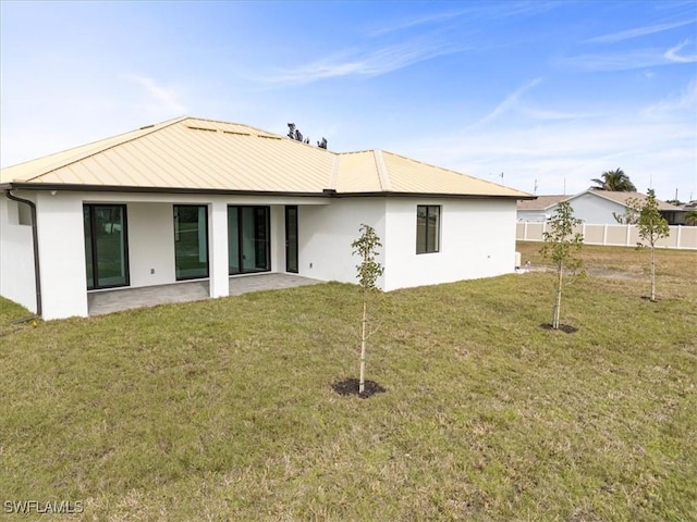 back of house featuring a lawn and a patio