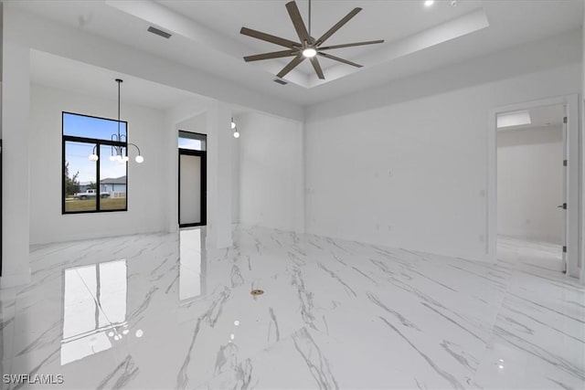 spare room with ceiling fan and a tray ceiling