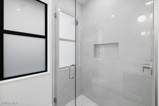 bathroom with a shower with door