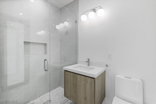 bathroom featuring toilet, a shower with door, and vanity