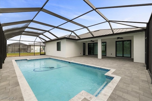 view of swimming pool featuring ceiling fan, a lanai, and a patio area