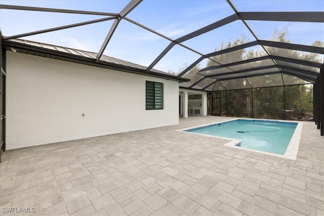 view of swimming pool with a patio area and a lanai