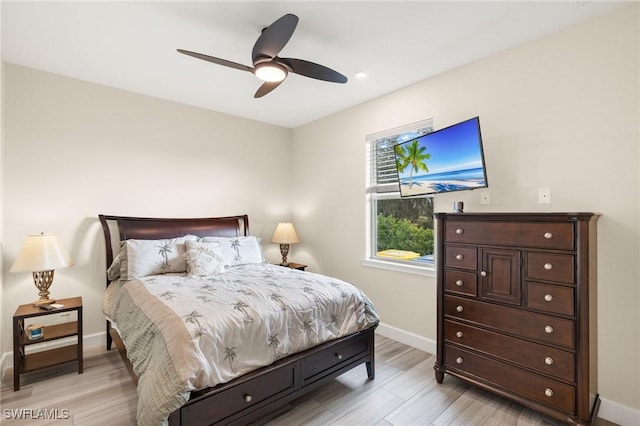 bedroom with a ceiling fan, light wood finished floors, and baseboards