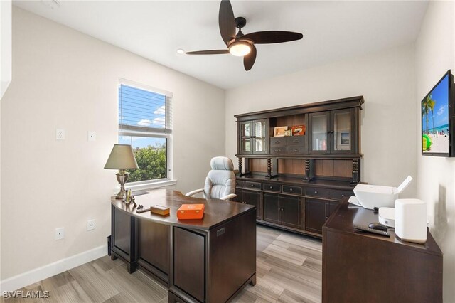 office area with ceiling fan, baseboards, and light wood-style flooring